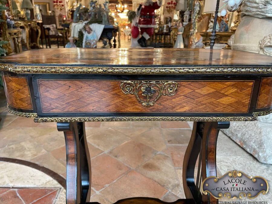 <h2>Tavolino antico da lavoro.</h2> <em>Tavolino antico da lavoro</em> con gamba a lira; intarsi con legni pregiati e bronzi a rilievo. Epoca primi 1800.