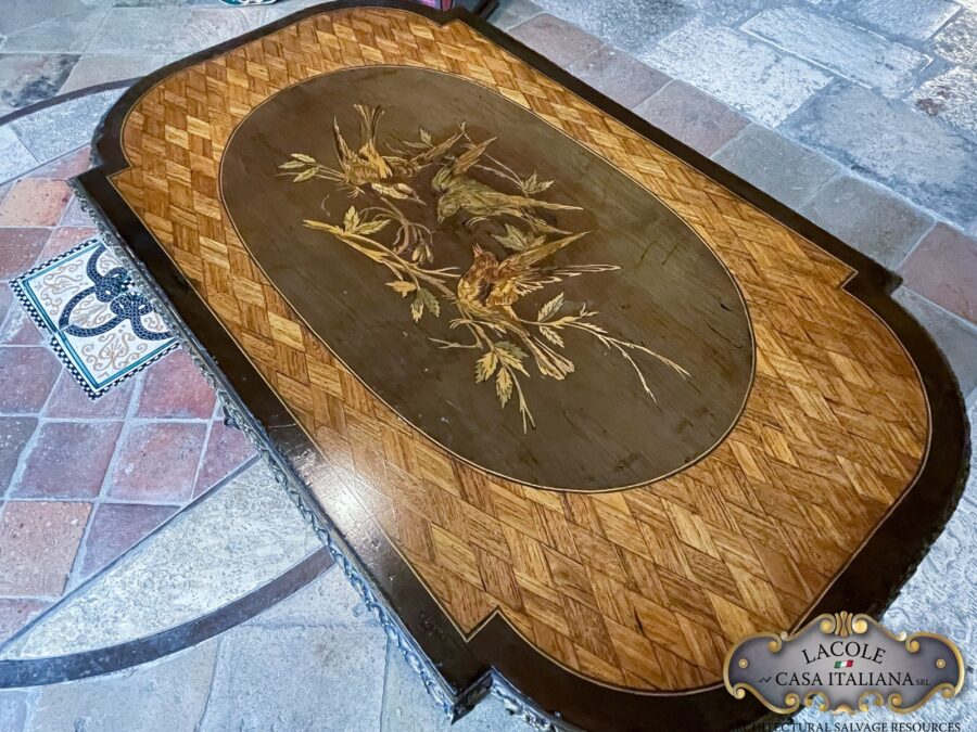 <h2>Tavolino antico da lavoro.</h2> <em>Tavolino antico da lavoro</em> con gamba a lira; intarsi con legni pregiati e bronzi a rilievo. Epoca primi 1800.