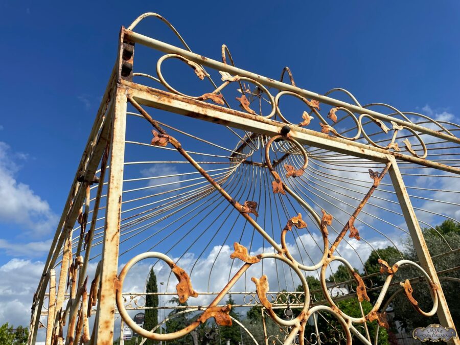 Handcrafted white iron gazebo, beautiful floral decorations and arched openings.